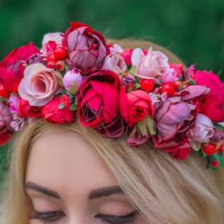 Eine Frau trägt einen Blumenkranz auf ihrem Kopf und posiert für ein Foto.