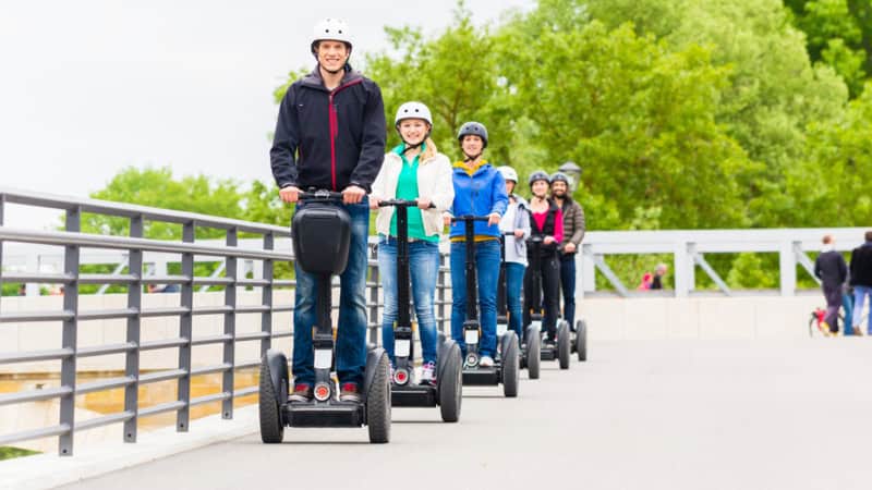 Die Teilnehmer einer Segway Tour in Köln fahren auf einer Brücke.
