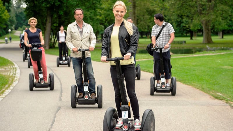 Die Teilnehmer einer Segway Tour in Köln fahren durch den Park.