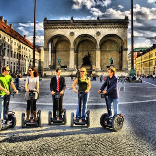 Segway Tour Teilnehmer posieren für ein Gruppenfoto in München, auf dem Odeonsplatz.