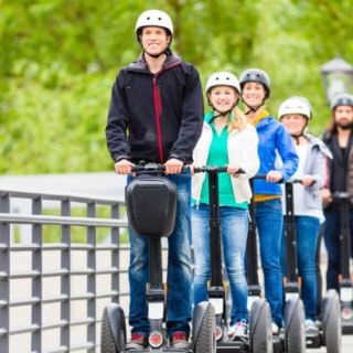 Die Teilnehmer einer Segway Tour in Regensburg fahren auf einer Brücke.