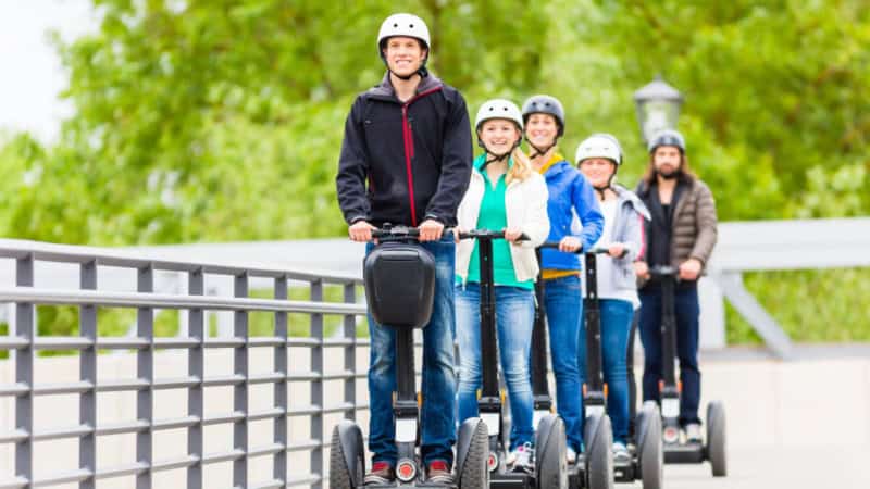 Die Teilnehmer einer Segway Tour in Regensburg fahren auf einer Brücke.