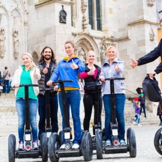Teilnehmer einer Segway Tour in Regensburg posieren für ein Gruppenfoto in der Stadt.