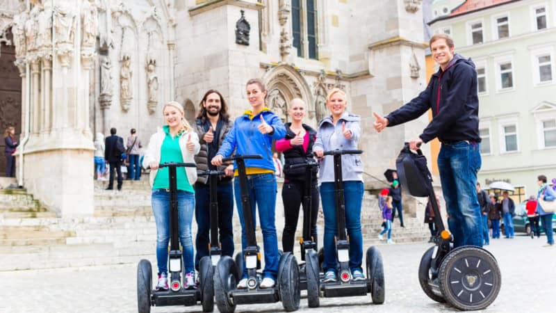 Teilnehmer einer Segway Tour in Regensburg posieren für ein Gruppenfoto in der Stadt.