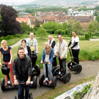 Ein Gruppenfoto von Segway-Tour-Teilnehmer, die Stadt Stuttgart im Hintergrund.