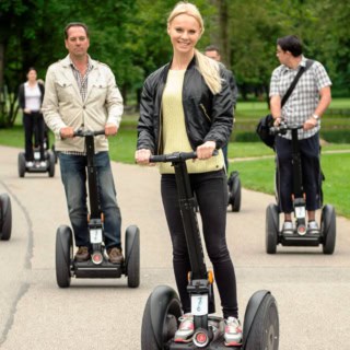 Die Teilnehmer einer Segway Tour in Stuttgart fahren durch den Park.