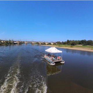 vorjapanpalais Floß fährt auf der Elbe am Japanischen Palais vorbei.