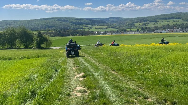 Quads fahren auf einem Feldweg.