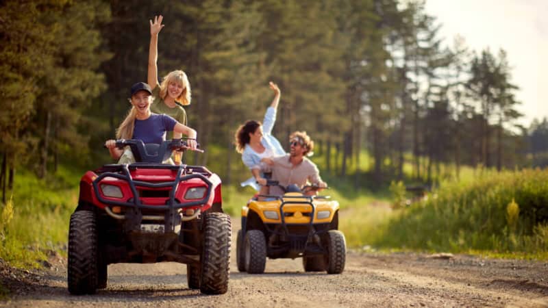 4 Personen fahren auf 2 Quads durch den Wald während einer Quad Tour.