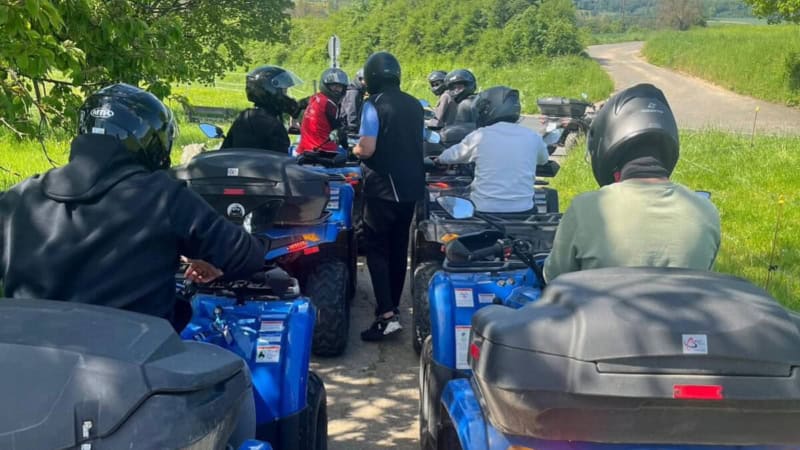 Teilnehmer einer Quad Tour fahren gemeinsam über grünes, unbefestigtes Gelände.