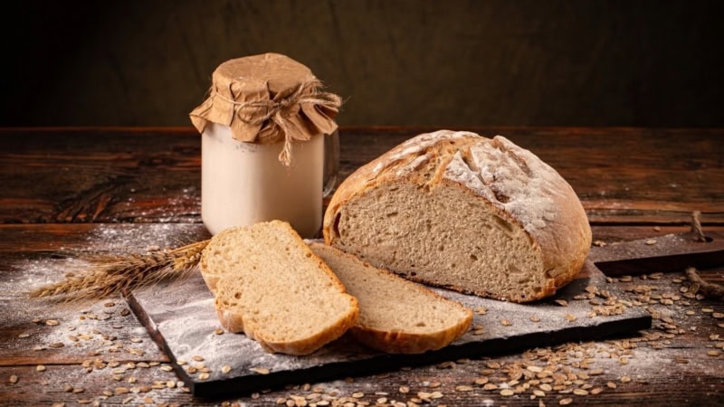 Frisches, geschnittenes Brot mit Glas Mehl auf Holzbrett - Backkurs bei Frankfurt