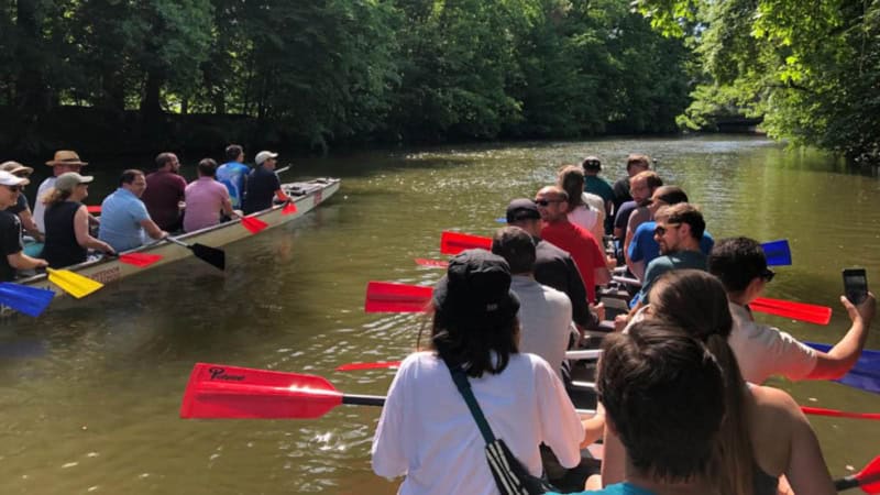 Fahrt in der Gruppe auf Drachenbooten durch einen Kanal mit idyllischer Waldlandschaft.