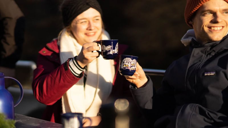 Pärchen beim anstoßen mit Glühwein und glücklichen Lächeln.