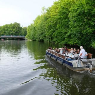 Motorboot in Fahrt auf einen Kanal umgeben von Bäumen.