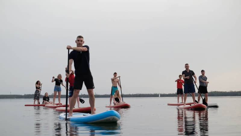eine Gruppe von stand up paddle Fahrern fährt über einen See
