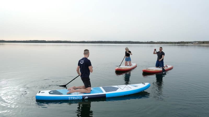 3 stand up paddle Fahrer knien auf ihren Board auf einem See