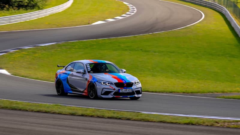 Der BMW M2 Competition fährt mit hoher Geschwindigkeit aus der Kurve auf einer Rennstrecke.