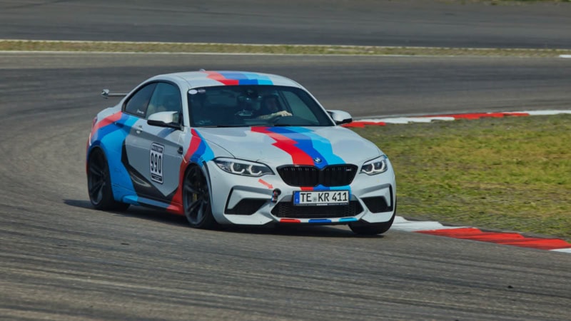 Der BMW M2 Competition fährt schnell in eine Kurve rein.