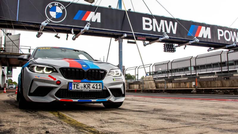 Der BMW M2 Competition steht in der Boxengasse einer Rennstrecke.