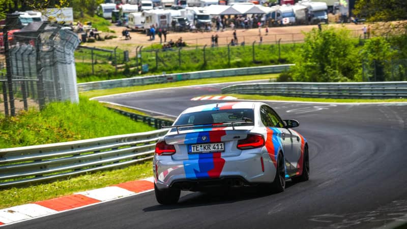 Zusehen ist das Heck des BMW M2 Competition, der die Rennstrecke entlang fährt.