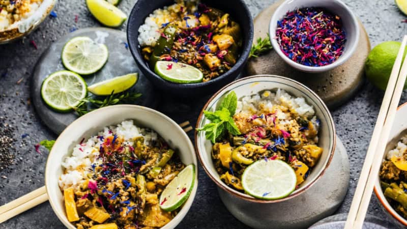 Orientalische Reisspeisen mit bunten Blumen verziert in Schalen.