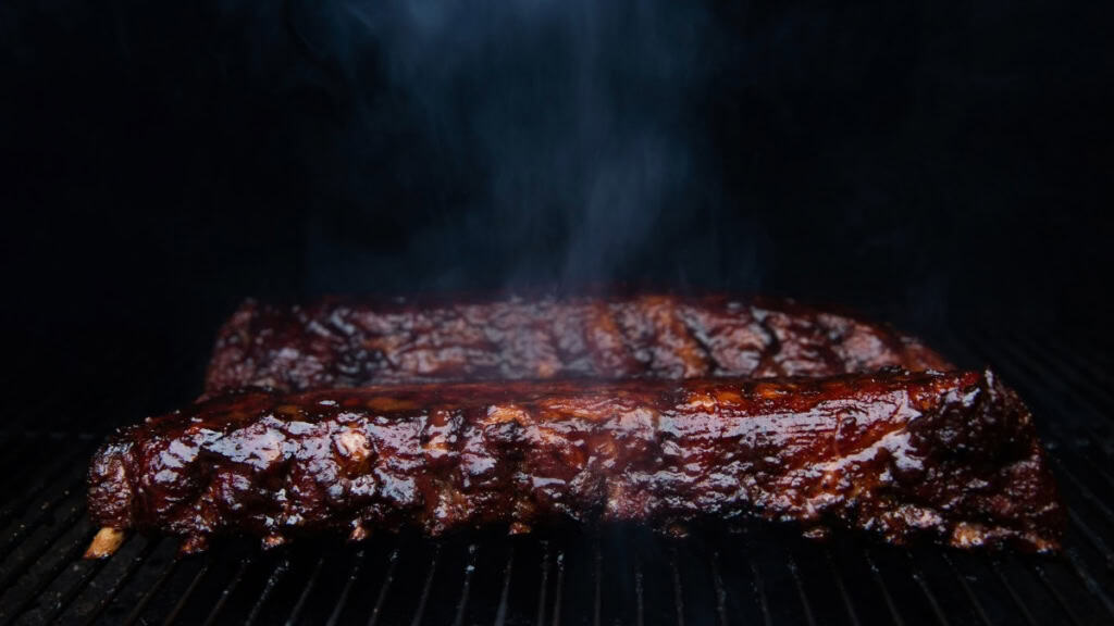 Kochkurs-smoker-fleisch Fleisch welches in einem Smoker grillt.