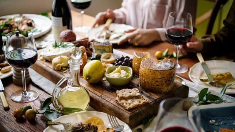 Eine Gruppe Kochkursteilnehmer, die zusammen ihre zubereiteten Tapas essen.