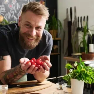 Ein Kochlehrer eines Veganen Kochkurses der lächelt.