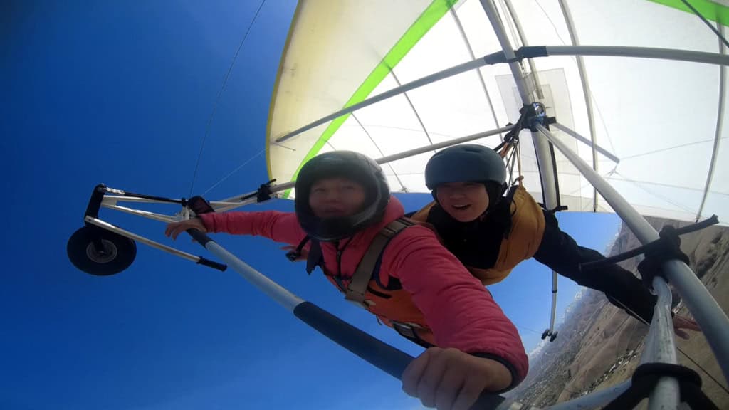 drachen-tandemflug-actioncam-front Ein Actioncam Foto vom Drachen aus. Man sieht beide Flieger wie sie eine Kurve fliegen und sich freuen.