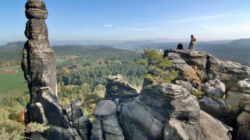 Bergsteiger stehen auf dem Gipfel eines Felsens in der Sächsischen Schweiz.