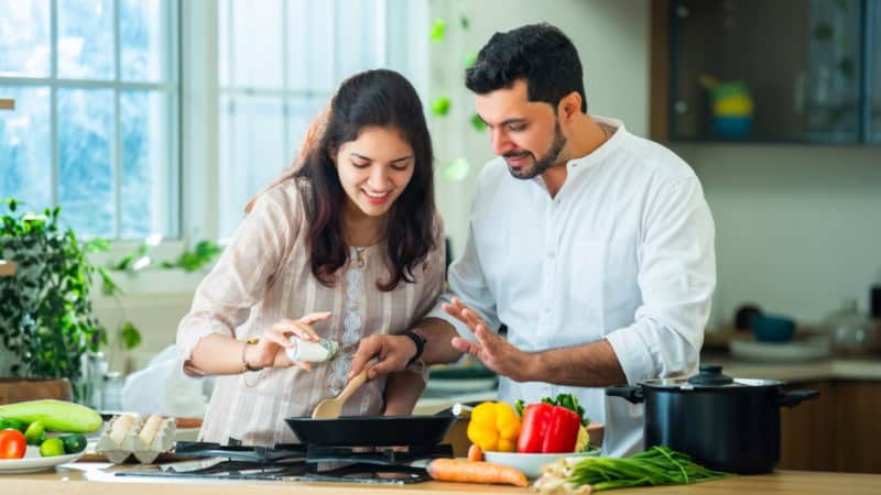 Ein Paar kocht gemeinsam ein indisches Gericht.