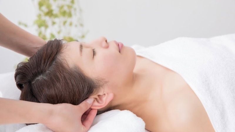 Nacken und Ohren werden bei der AromaTouch Behandlung sanft mit ätherischen Ölen berührt.