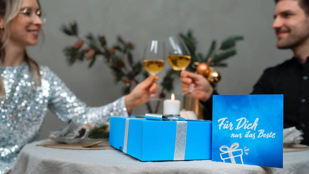 Geschenkbox - Weihnachten - anstoßen Ein Paar stößt auf die Geschenkte Erlebnis Geschenkbox an Weihnachten an.