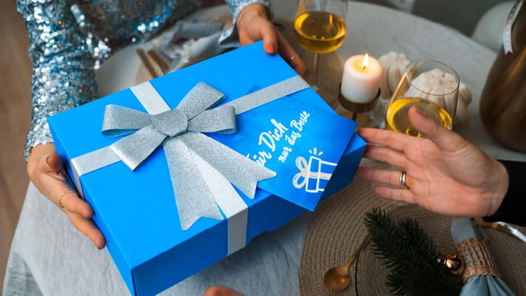 Geschenkbox - Weihnachten - ueberreichen Eine Geschenkbox wird am Esstisch zu Weihnachten übergeben.