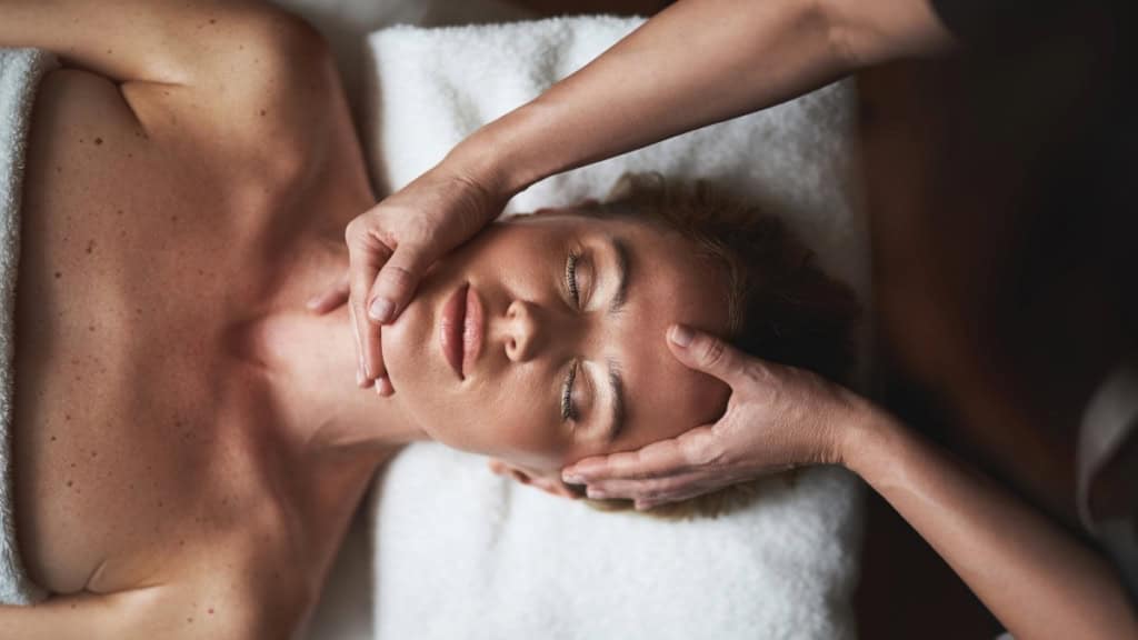 Gesichtsmassage-Frau Eine Frau erhält eine beruhigende Gesichtsmassage.