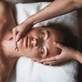 Eine Frau erhält eine beruhigende Gesichtsmassage.