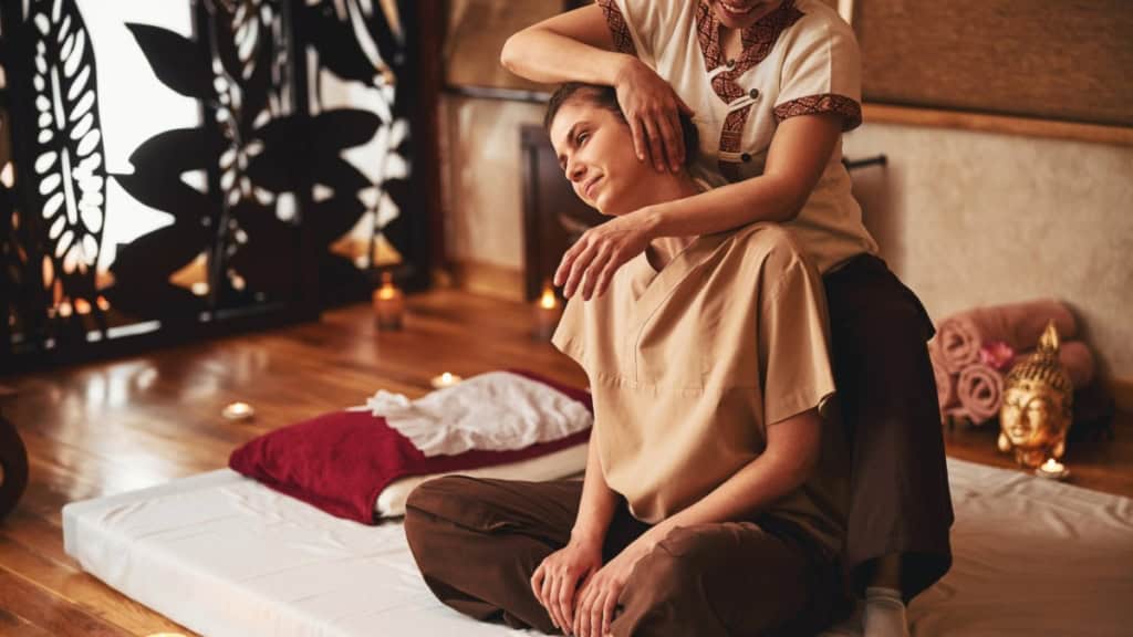 Thai Ganzkörpermassage-Dehnung Eine Frau bekommt bei einer traditionellen Thai Massage den Hals gedehnt.
