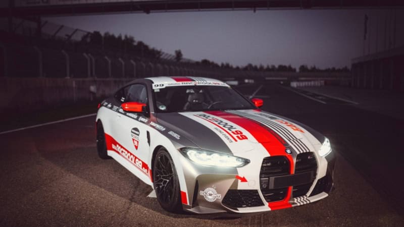 BMW M4 vor der Rennstrecke mit eingeschalteten Licht