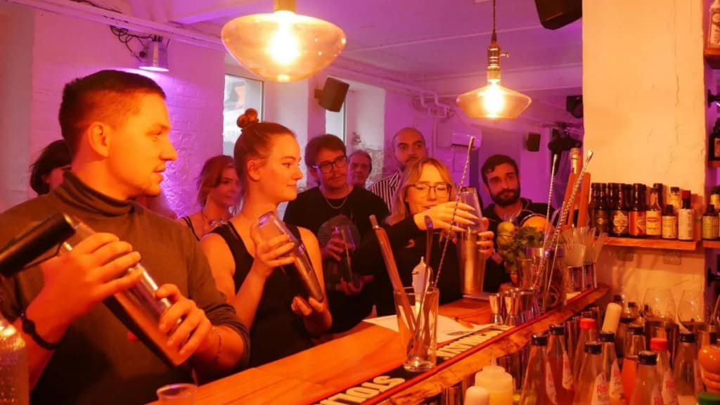 Cocktailkurs-in-Frankfurt-Teilnehmer Eine Freundesgruppe mischt Cocktails bei einem Cocktail Workshop in einer Bar in Frankfurt.