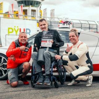 Instruktoren und Handicap Fahrer vor Porsche 911 GT3 Cup bei Übergabe der Urkunde an der Rennstrecke