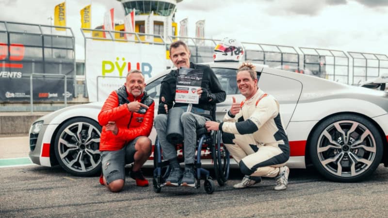 Instruktoren und Handicap Fahrer vor Porsche 911 GT3 Cup bei Übergabe der Urkunde an der Rennstrecke