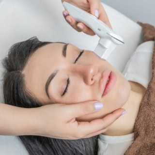 Eine Frau liegt entspannt bei einer Kosmetikbehandlung - Hautanalyse in Kassel