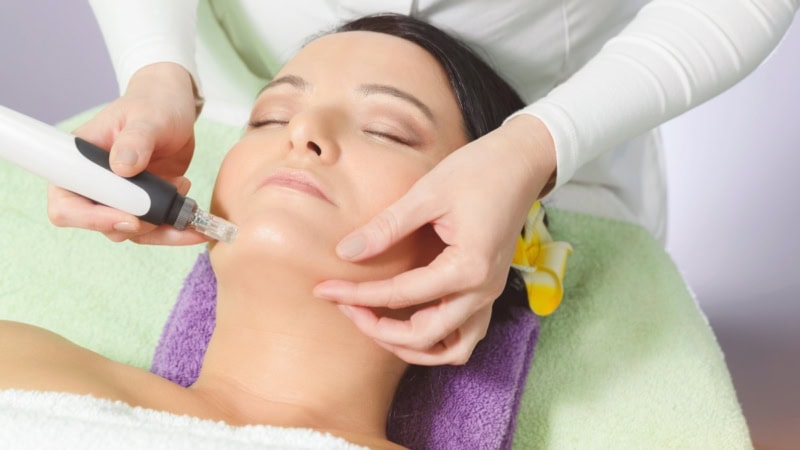 Behandlung beim Lifting ohne Op, eine Frau liegt auf dem Behandlungsstuhl.