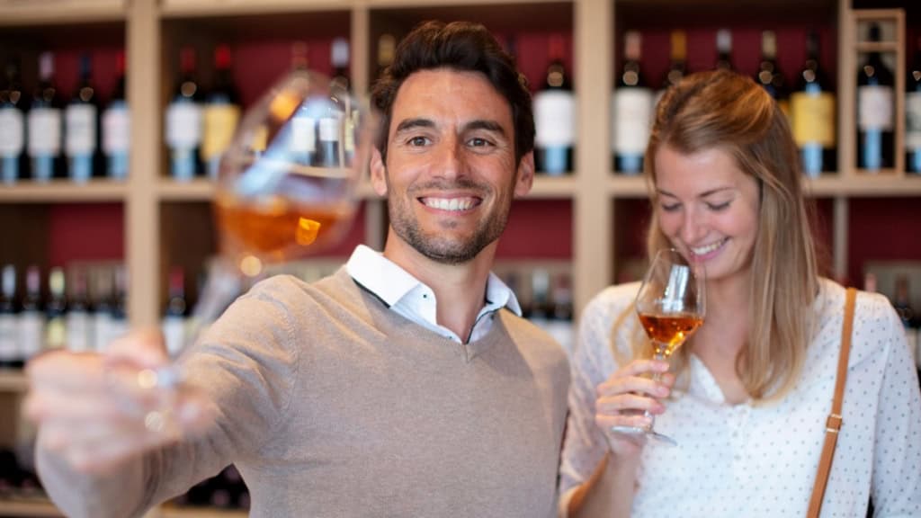 Ein Paar aus Mann und Frau verkostet Whisky aus Gläsern.