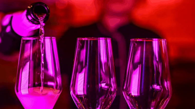 Pink beleuchtete Sektgläser werden mit Champagner für eine Verkostung befüllt.