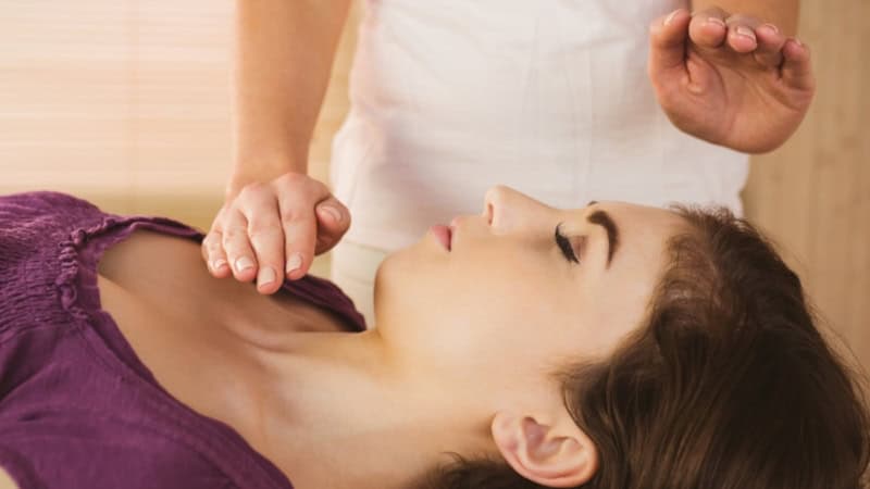 Eine Frau die eine Energiebehandlung von einer erfahrenen Therapeutin bekommt.