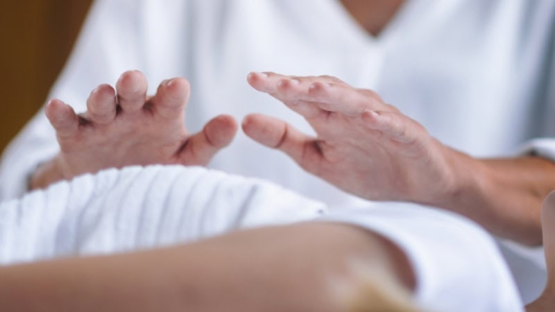 Ein close shot von einer Energiebehandlung bei der Hände über die Brust gehalten werden.