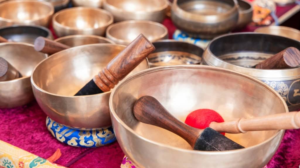 Klangschalen-verschiedene Viele verschiedene Klangschalen die auf Kissen stehen.