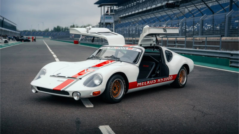 Der Melkus RS 1000 mit offenen Flügeltüren auf einer Rennstrecke.