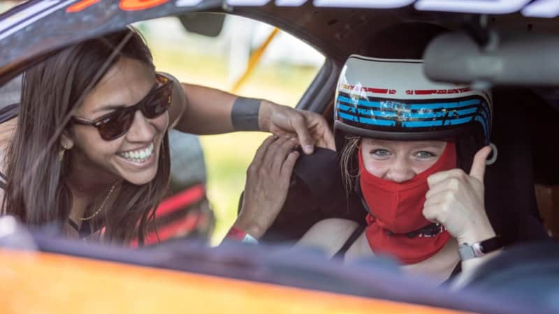 Zwei Frauen bereiten sich im Cockpit eines Autos für eine Fahrt vor und freuen sich.